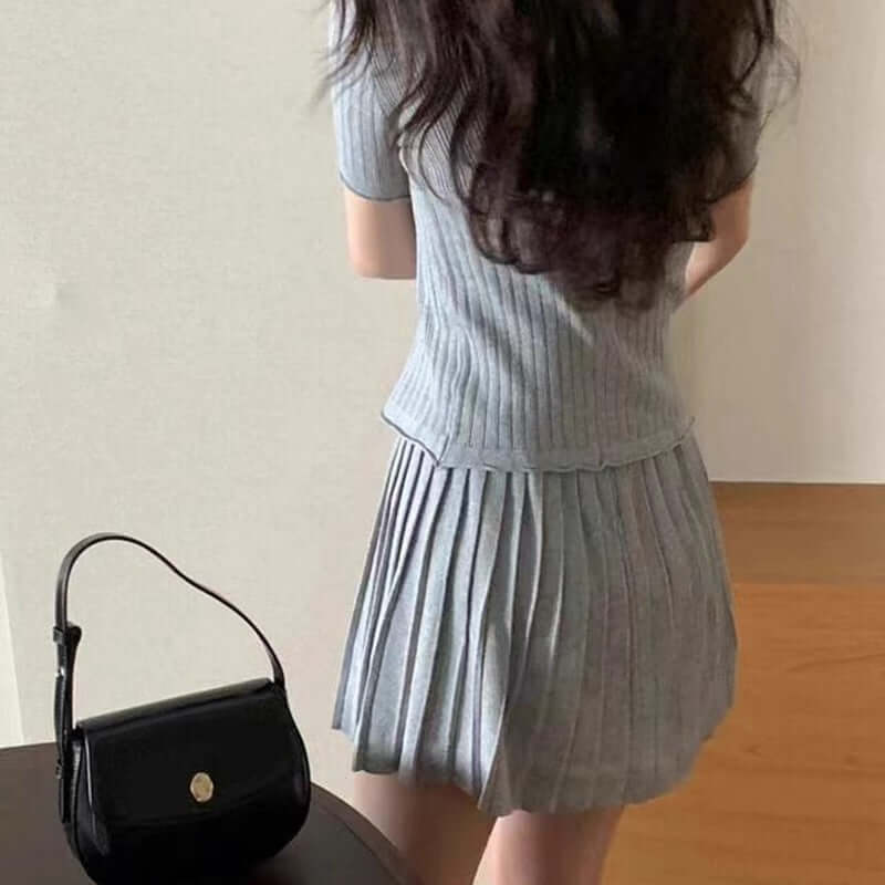Chic, youthful gray pleated dress paired with a stylish black handbag, showcasing a trendy back view.