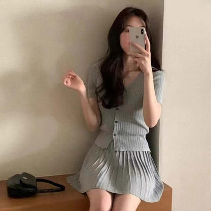 Stylish gray pleated dress paired with a matching cardigan, showcasing a chic and youthful appearance.