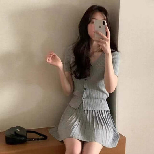 Stylish gray pleated dress paired with a matching cardigan, showcasing a chic and youthful appearance.